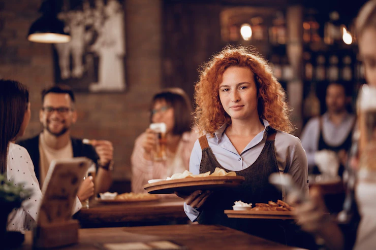 female-student-working-parttime-as-waitress-serving-food-guest-pub